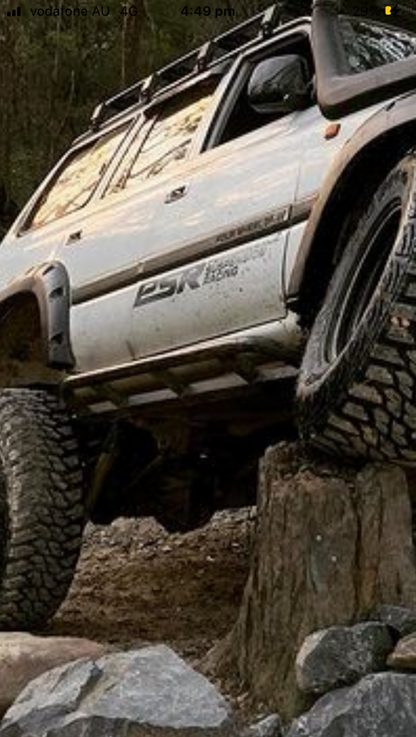 Image of Nissan Gu Patrol Rock Sliders: Heavy-duty, black steel rock sliders specifically designed for Nissan Gu Patrol vehicles, offering enhanced off-road protection and durability. These rugged sliders seamlessly integrate with the vehicle's body, providing reliable defense against rocks and debris during challenging off-road adventures.