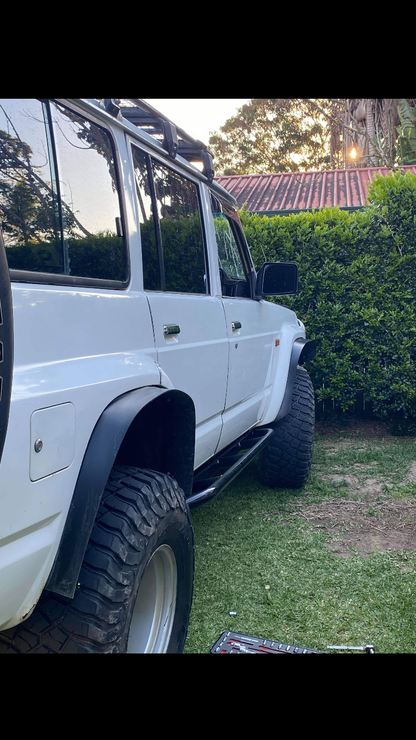 Image of Nissan GQ Patrol rock sliders: Sturdy black steel rock sliders tailored for Nissan GQ Patrol models, crafted to withstand rugged off-road terrain. These sliders seamlessly integrate with the vehicle's design, offering reliable protection against rocks and obstacles during adventurous journeys.